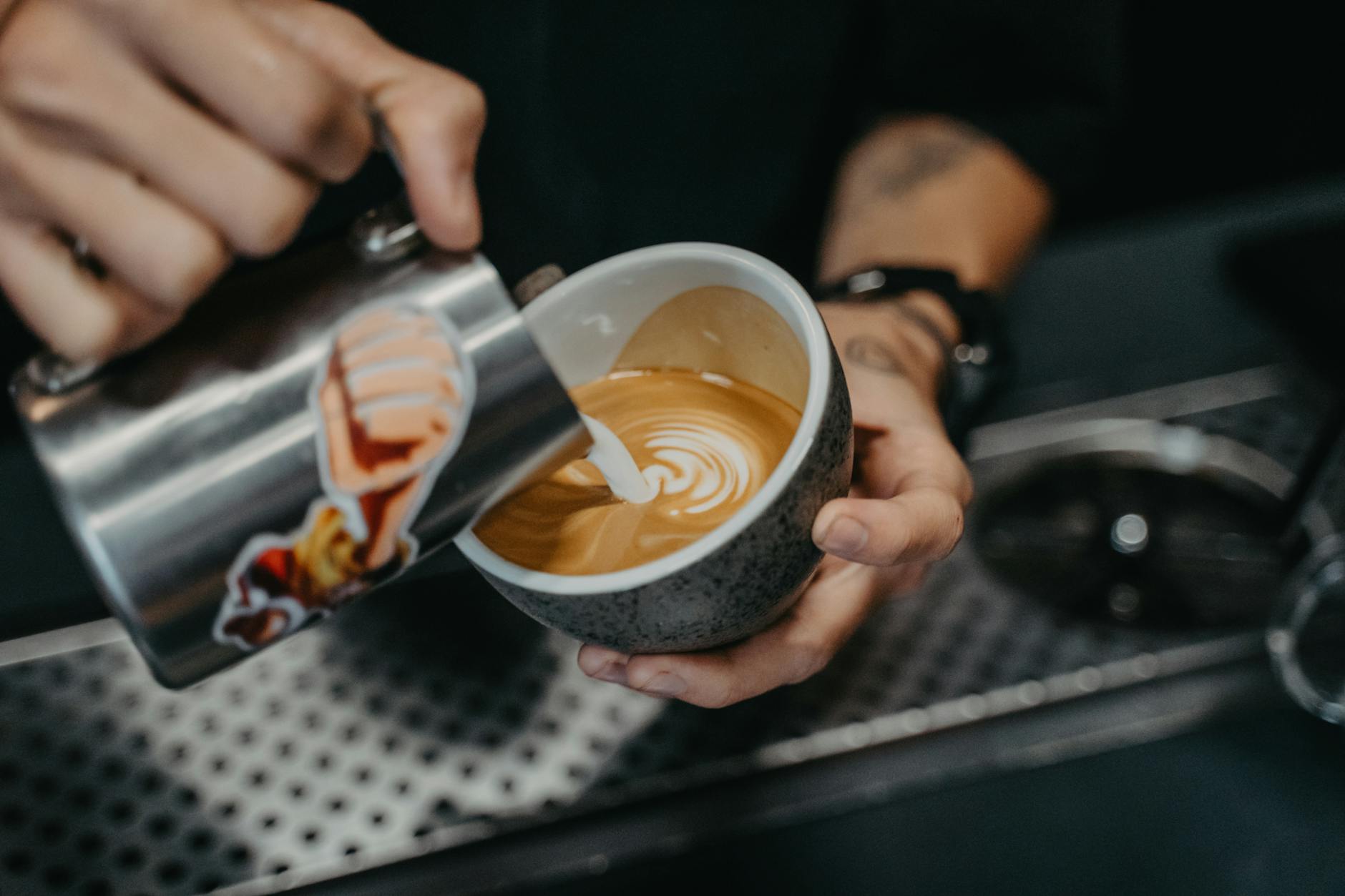 Barista gießt Latte Art in eine Tasse